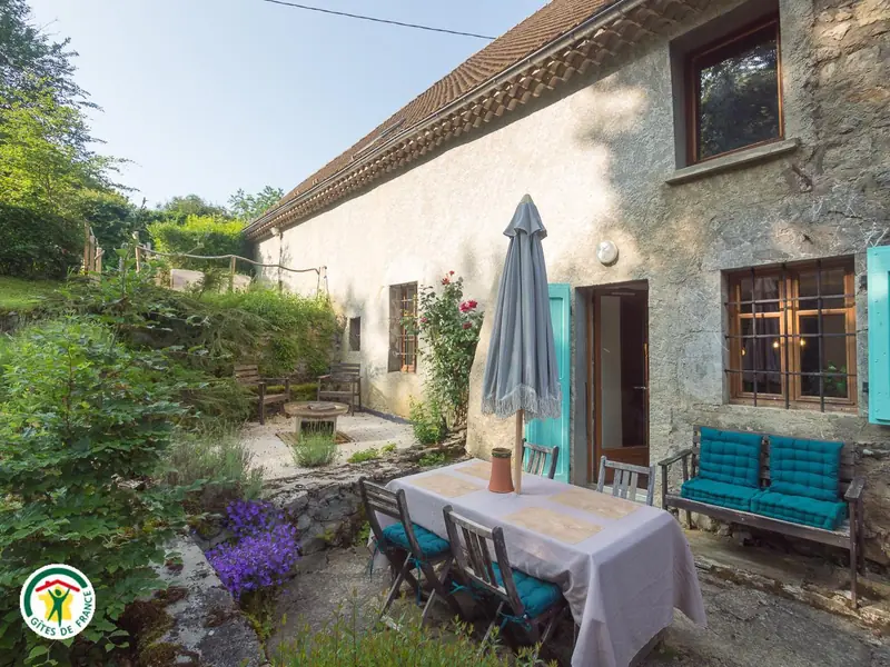 La terrasse et les volets turquoise du gîte au soleil du soir
